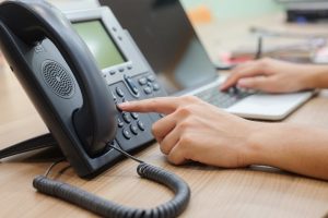 Employee using VoIP phone and computer simultaneously