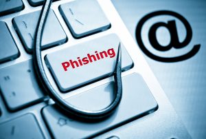 The word “Phishing” is printed in red on a keyboard’s enter key with a fishing hook surrounding it.