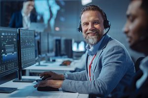 A technical support professional looks straight ahead, smiling and wearing a headset.
