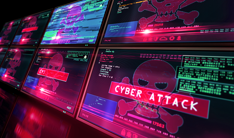 Computer monitors with skulls and cross bones and CYBERATTACK in a red box.