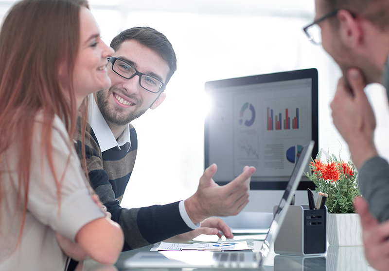 A team of workers using technology successfully to work and smile.