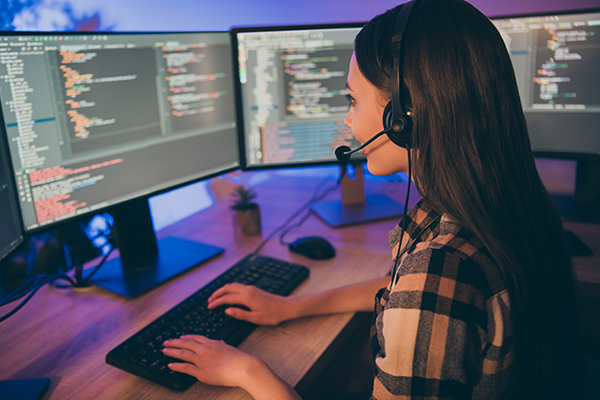 A woman talking on a headset while working IT support.
