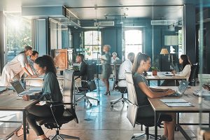 An office full of people working on their laptops.