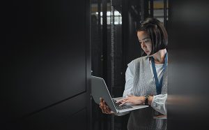 Woman with laptop in a data center.