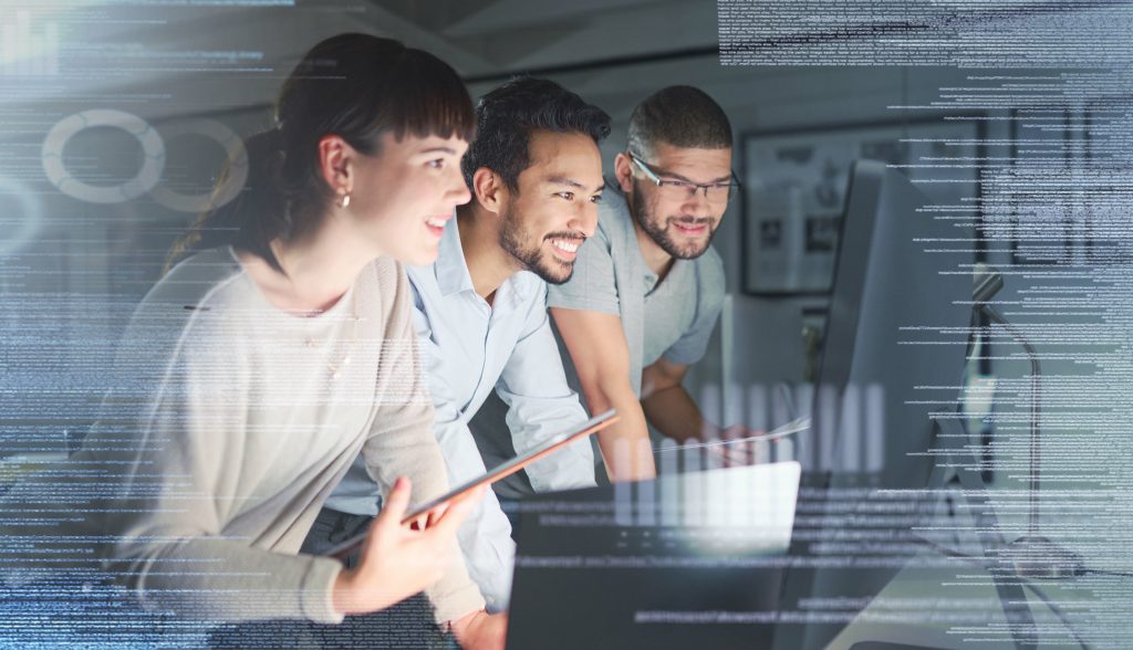 Three businesspeople are smiling and looking at a computer screen.