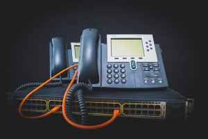Two handheld phone systems plugged into a network router.