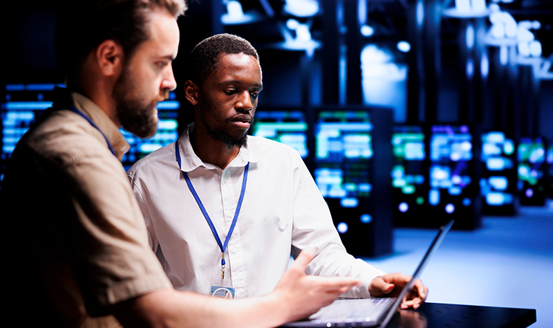 Two IT technicians working on a computer.