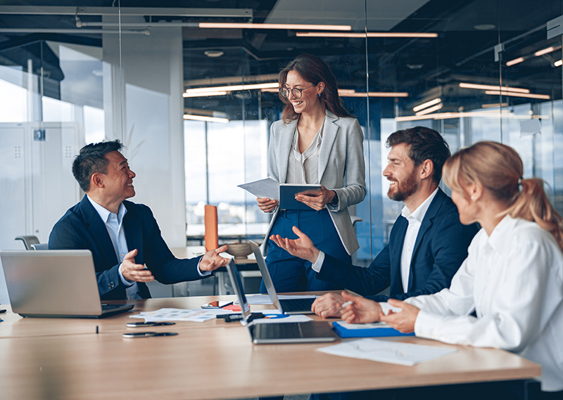 A group of business people smiling while working on their computers.