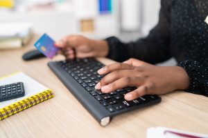 A woman using a credit card on her laptop.