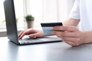 A woman using a credit card on her desktop computer.