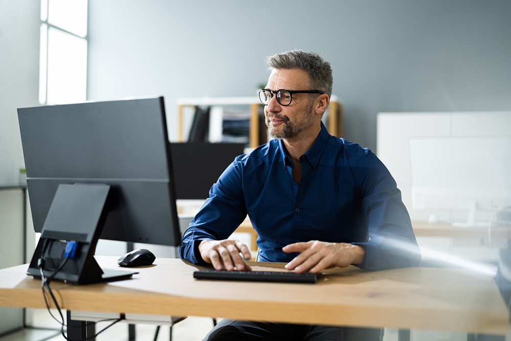 a man using his computer in an office